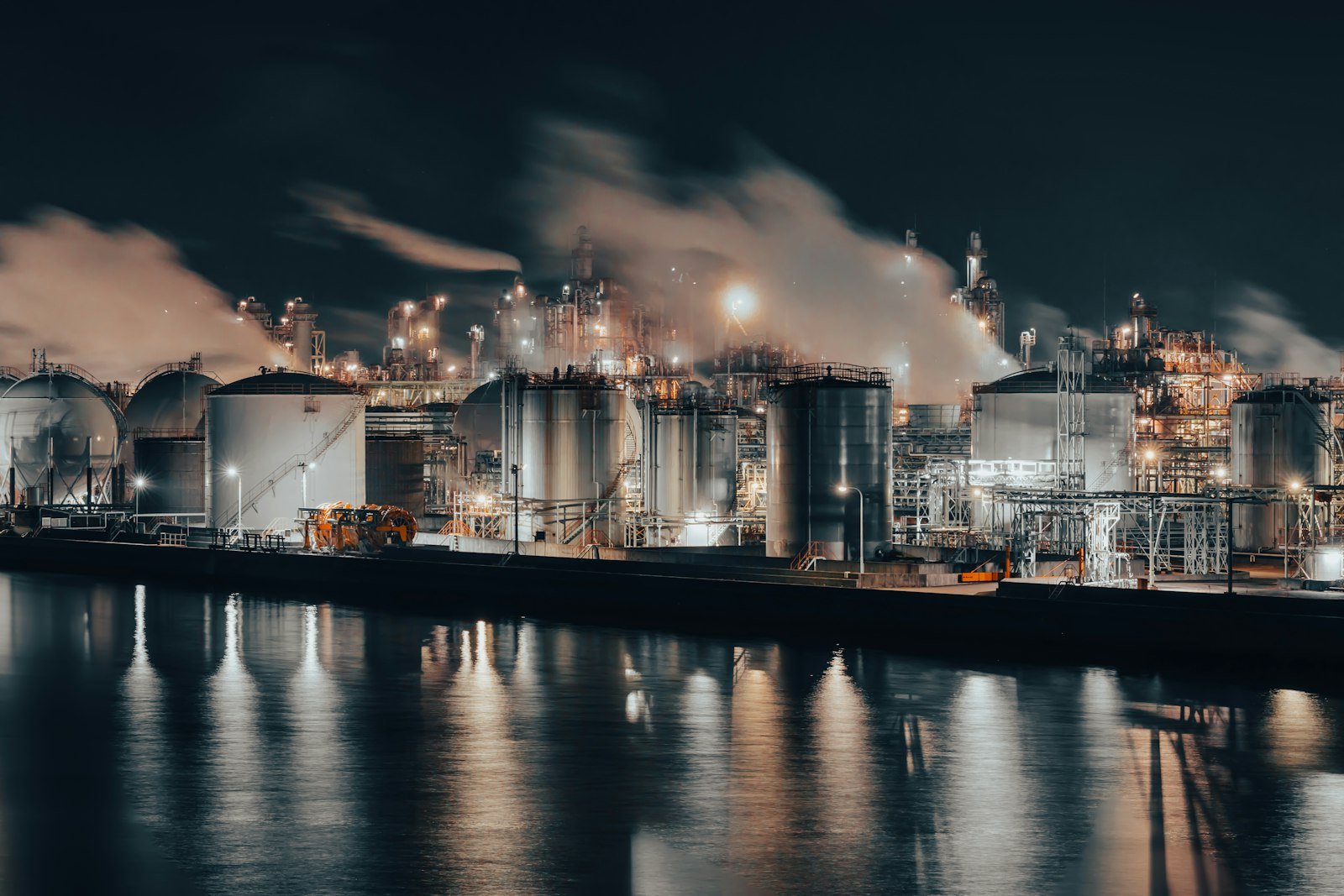 Industrial plant at night reflected in water