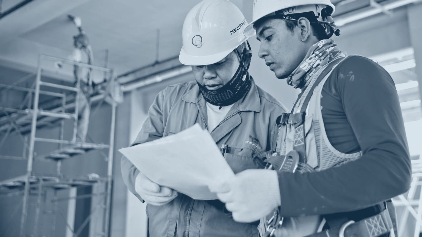 Construction workers reviewing drawings on a building site